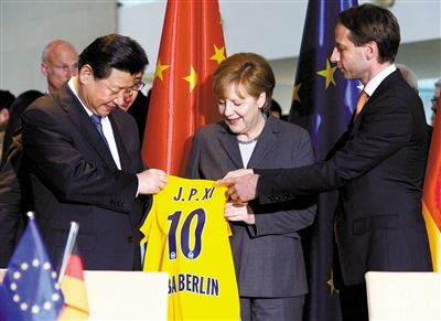 28日，柏林，欧绿保集团首席执行官Axel Schweitzer（右）向习近平赠送阿尔巴柏林篮球队球衣。